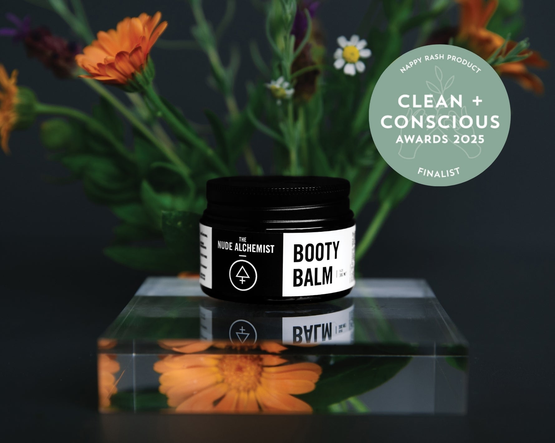 Product shot of nappy rash balm with calendula flowers in the background.