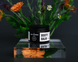 Product shot of nappy rash balm with calendula flowers in the background.
