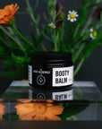 Product shot of nappy rash balm with calendula flowers in the background.